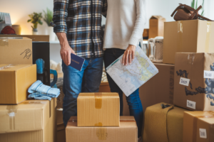 Couple moving to a new country with packed boxes and passports