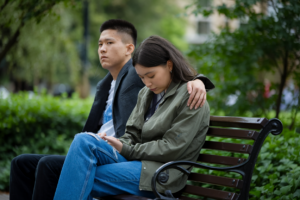 A photo representing emotional affairs, showing subtle emotional tension between two individuals in a serene park setting.