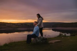 A couple in a long-term relationship sharing a quiet moment on a cliff overlooking a serene landscape.